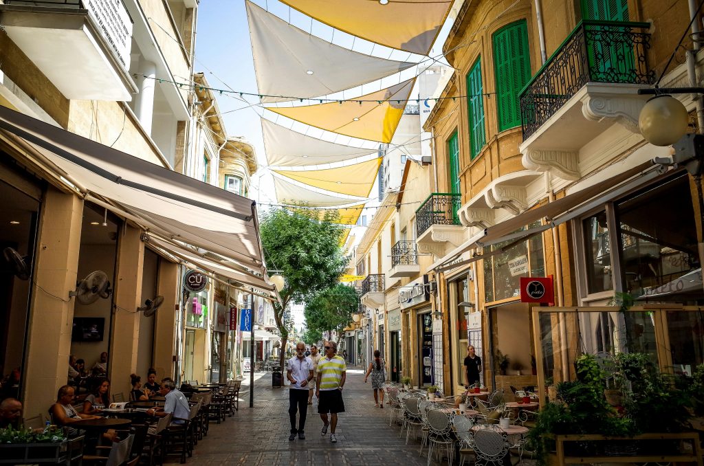 pexels photo 2308592 2308592 Bustling street in Nicosia, Cyprus with cafes, shops, and people under colorful shades.