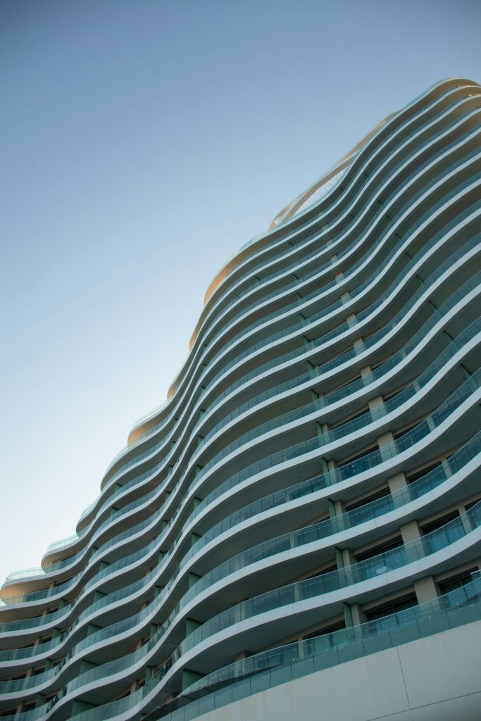 Elegant contemporary skyscraper with curved lines in Limassol, Cyprus against a blue sky.